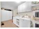 A functional laundry room with modern washer, dryer and extra storage space at 9834 W Evergreen Dr, Sun City, AZ 85373