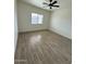 A bright, freshly painted bedroom with wood-look flooring has a window and a ceiling fan at 10281 W Concordia Dr, Arizona City, AZ 85123