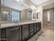 Well-lit bathroom featuring a dual sink vanity with dark cabinetry and neutral countertops, plus decorative lighting at 10778 W Whitehorn Way, Peoria, AZ 85383