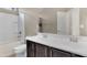 Clean bathroom featuring a shower/tub combo, dual sink vanity with dark cabinetry, and tile flooring at 10778 W Whitehorn Way, Peoria, AZ 85383