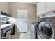 Laundry room featuring a work desk, front load washer and dryer, and utility sink at 10778 W Whitehorn Way, Peoria, AZ 85383