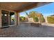 Covered patio featuring pavers and an outdoor fireplace with a view of the yard at 10778 W Whitehorn Way, Peoria, AZ 85383