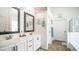 Bright bathroom featuring double sinks, white cabinets, decorative mirrors, and beach-inspired décor for a relaxing ambiance at 11460 E Dartmouth St, Mesa, AZ 85207