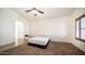 Airy bedroom with carpet flooring, bright windows, a ceiling fan, and access to other areas of the home at 11460 E Dartmouth St, Mesa, AZ 85207