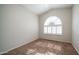 Bright, carpeted bedroom with an arched window and plantation shutters at 11460 E Dartmouth St, Mesa, AZ 85207