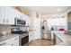 Close-up of stainless steel microwave, oven, and gas cooktop in the kitchen with white cabinets at 11460 E Dartmouth St, Mesa, AZ 85207