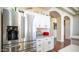 Stainless steel refrigerator and white cabinets in the kitchen, with a view to the living space at 11460 E Dartmouth St, Mesa, AZ 85207