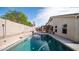 Backyard swimming pool with lush landscaping and a water feature, set against a clear blue sky at 11460 E Dartmouth St, Mesa, AZ 85207