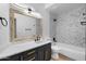 Modern bathroom with a framed mirror, stylish vanity, and a tiled shower-tub combination at 1157 N Date Palm Dr, Gilbert, AZ 85234