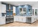 Kitchen featuring stainless steel appliances, white cabinetry, a gas range, and a modern geometric backsplash at 1157 N Date Palm Dr, Gilbert, AZ 85234