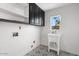 Functional laundry room featuring modern cabinets, a sink, and unique patterned flooring at 1157 N Date Palm Dr, Gilbert, AZ 85234