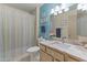 Bright bathroom showcasing a neutral palette, shower with curtains, and a vanity with a solid countertop at 12434 W Fieldstone Dr, Sun City West, AZ 85375