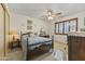 The bedroom features a ceiling fan, a cozy bed, and a traditional-style vanity with carpet flooring at 12434 W Fieldstone Dr, Sun City West, AZ 85375