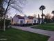 Elegant home with a red tile roof, manicured landscaping, and a brick driveway, beautifully illuminated at dusk at 1307 W Palm Ln, Phoenix, AZ 85007