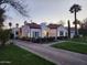 Inviting home with well-lit exterior, lush landscaping, a classic red tile roof, and a neatly paved driveway at 1307 W Palm Ln, Phoenix, AZ 85007