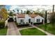 Charming home with a red tile roof, well-manicured lawn, lush landscaping, and a welcoming brick pathway at 1307 W Palm Ln, Phoenix, AZ 85007