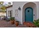 Close-up view of the teal front door with arched entry, terracotta steps, and decorative tile accents at 1307 W Palm Ln, Phoenix, AZ 85007