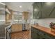 Charming kitchen featuring terracotta flooring, stainless steel appliances, and light wood cabinets at 1307 W Palm Ln, Phoenix, AZ 85007