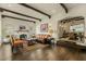 Elegant living room with dark hardwood floors, exposed beams, fireplace, and an open dining area at 1307 W Palm Ln, Phoenix, AZ 85007