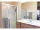 Bright bathroom with a glass-enclosed shower, vanity, and ample mirror space at 14465 W Winding Trl, Surprise, AZ 85374