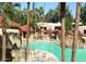 Large community pool surrounded by mature palm trees and lounge seating near residential buildings at 14465 W Winding Trl, Surprise, AZ 85374