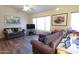 Cozy living room features comfortable seating, ample natural light, and vinyl plank flooring at 14465 W Winding Trl, Surprise, AZ 85374