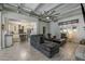 Open-concept living room boasts a modern ceiling fan, comfortable gray sectional sofa, and seamless flow into the kitchen at 1610 W Wilshire Dr, Phoenix, AZ 85007