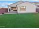 Backyard with artificial grass and a covered patio, perfect for outdoor living at 16416 W Cottontail Ln, Surprise, AZ 85387