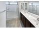 Modern bathroom with a glass-enclosed shower, dual sinks, and tile flooring at 16416 W Cottontail Ln, Surprise, AZ 85387