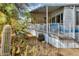 Covered patio with white railing is surrounded by lush desert landscaping including multiple cacti at 17200 W Bell Rd # 26, Surprise, AZ 85374