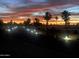 Evening shot of the illuminated community streets lined with towering palm trees, offering beautiful sunset views at 17200 W Bell Rd # 26, Surprise, AZ 85374