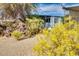 Desert landscaped yard features mature cacti and flowering bushes surrounding the blue home at 17200 W Bell Rd # 26, Surprise, AZ 85374