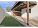 Carport features concrete block wall, wooden beams, turf grass, and leads to backyard at 1725 N Date -- # 23, Mesa, AZ 85201