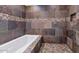 Luxurious bathroom offering a soaking tub with custom slate tile surround, a shower, and mosaic tile flooring at 17309 E Rosita Dr, Fountain Hills, AZ 85268