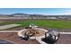 An aerial view captures a well-equipped community playground featuring play structures, picnic shelter, and open green spaces at 17569 W Victory St, Goodyear, AZ 85338