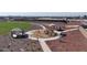 This aerial view shows a community park with a playground featuring slides, climbing structures, picnic ramada, and walking path at 17569 W Victory St, Goodyear, AZ 85338