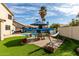 Sprawling backyard with manicured lawn, in-ground pool, patio, and vibrant landscaping at 1865 E Pinto Dr, Gilbert, AZ 85296