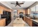 Kitchen island with granite countertop, black appliances, wood cabinets and view to dining room at 1865 E Pinto Dr, Gilbert, AZ 85296