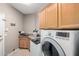 Well-equipped laundry room features granite countertops, upper cabinets and modern washer and dryer at 1865 E Pinto Dr, Gilbert, AZ 85296