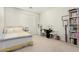 Bright bedroom with natural light, featuring a work desk and shelves with a comfortable bed for relaxation at 21487 N Greenway Rd, Maricopa, AZ 85138