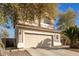 Two-story home featuring a large driveway, desert landscaping, and a neutral color palette at 21487 N Greenway Rd, Maricopa, AZ 85138