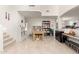 A bright living room with tile floors, a wooden dining table, and decorative bookshelves at 21487 N Greenway Rd, Maricopa, AZ 85138