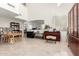 Open-concept living room with light flooring, high ceilings, and a piano at 21487 N Greenway Rd, Maricopa, AZ 85138