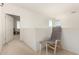 The loft has neutral carpet and an open doorway with a chair in the foreground, providing a casual relaxation space at 21487 N Greenway Rd, Maricopa, AZ 85138