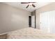 Comfortable bedroom with neutral walls, ceiling fan and walk-in closet at 21919 N Bradford Dr, Maricopa, AZ 85138