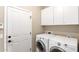 Laundry room featuring Whirlpool washer and dryer set, white cabinets and a white door at 21919 N Bradford Dr, Maricopa, AZ 85138