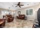 A warm living room featuring a ceiling fan, tile floors, and a cozy seating arrangement at 21919 N Bradford Dr, Maricopa, AZ 85138