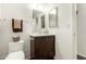 Bathroom featuring a dark wood vanity with a white sink, a large mirror, toilet, and towel rack at 2205 E Linda Ct, Phoenix, AZ 85022