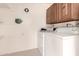 Bright laundry room with washer, dryer, overhead cabinets, and shelving at 2205 E Linda Ct, Phoenix, AZ 85022