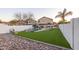 Expansive backyard with artificial grass, a rock-accented pool, and mature trees offering privacy at 2226 E Parkside Ln, Phoenix, AZ 85024